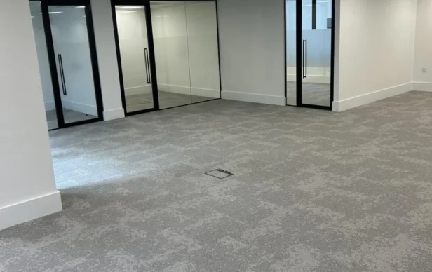 Office interior with glass partitions and gray carpet